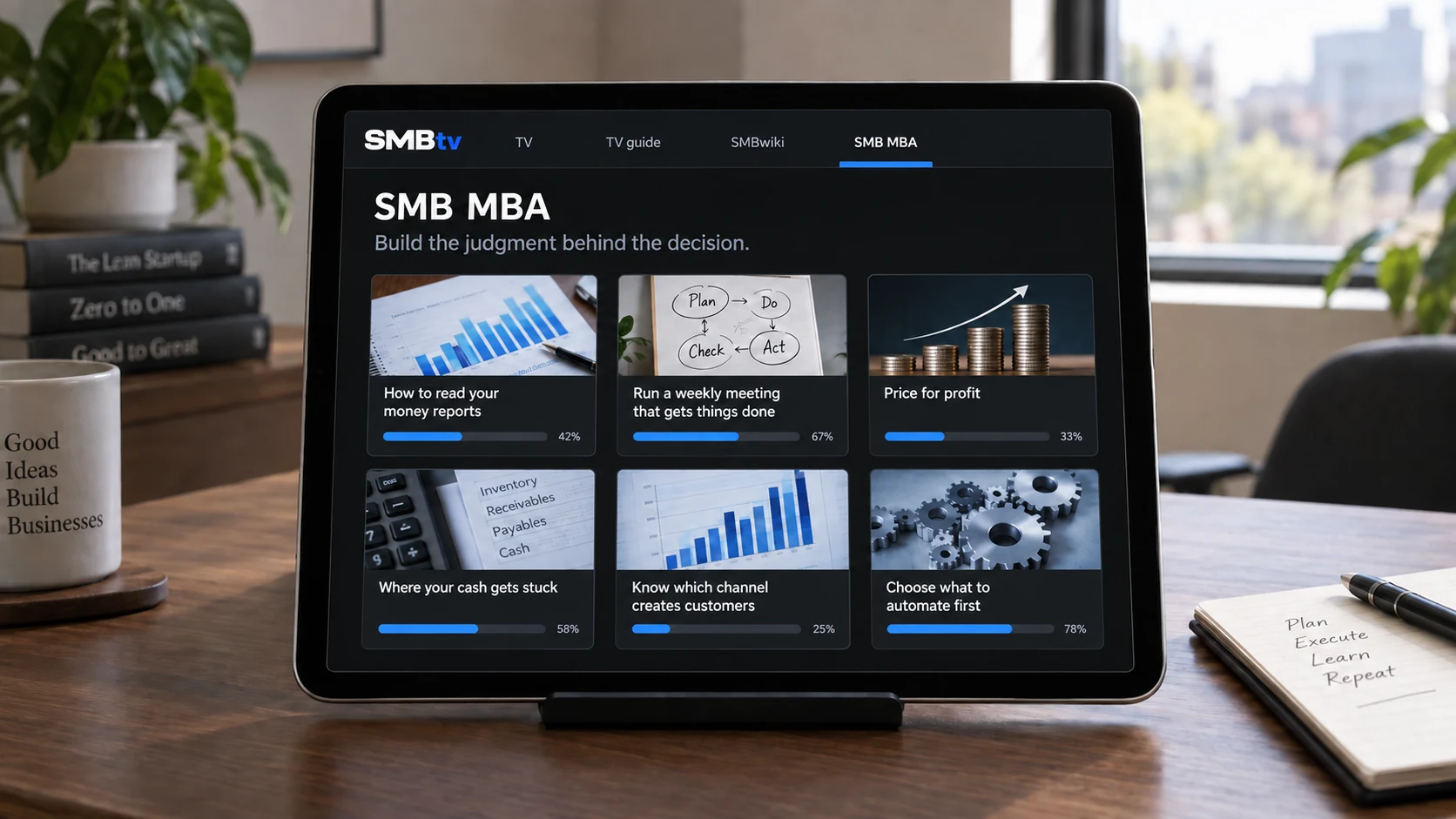 SMBtv and six SMB MBA lessons displayed beneath the glass of a level landscape iPad on an office desk
